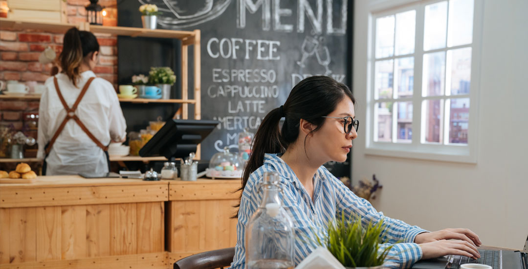 Woman using laptop in coffee shop