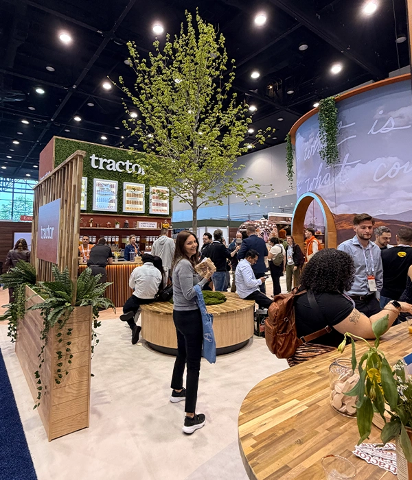 Tractor Beverage Co. booth with tree and natural seating